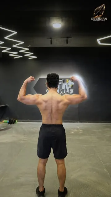 A member flexing his back under the zigzag LED ceiling.